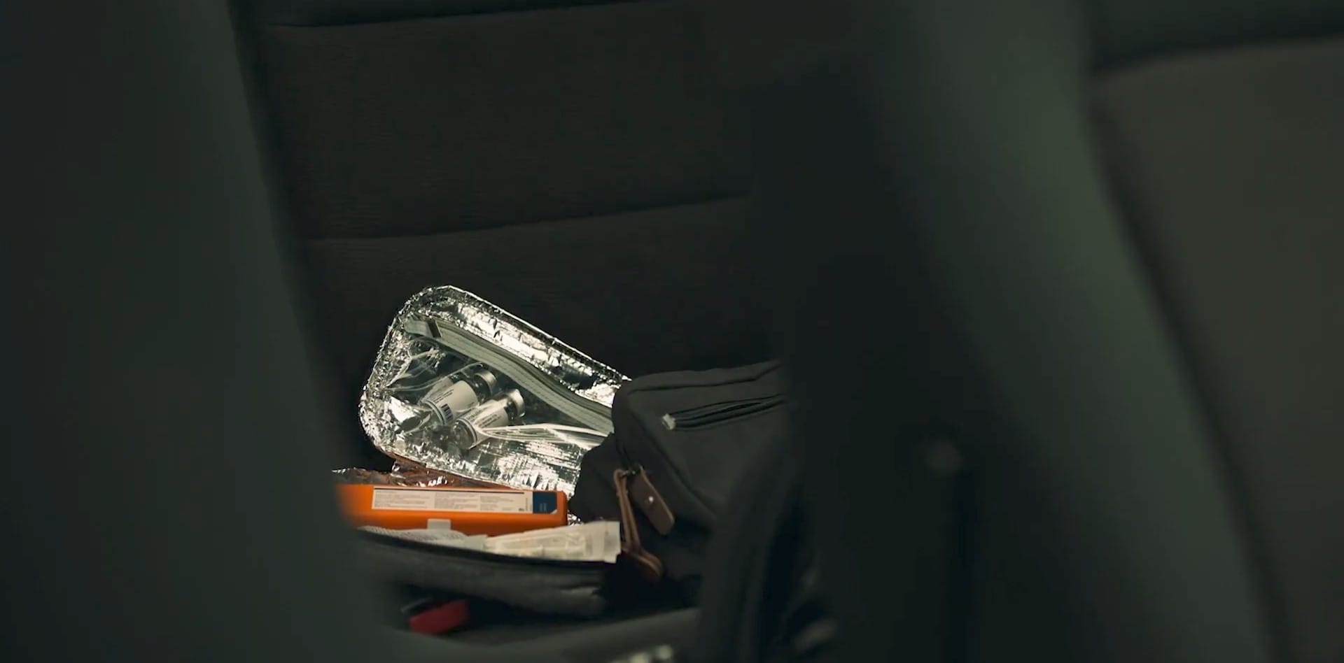 An insulin pack lays open in the back seat of a car.